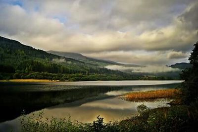 Scenic view of lake against cloudy sky