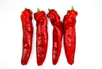 Close-up of red chili peppers against white background