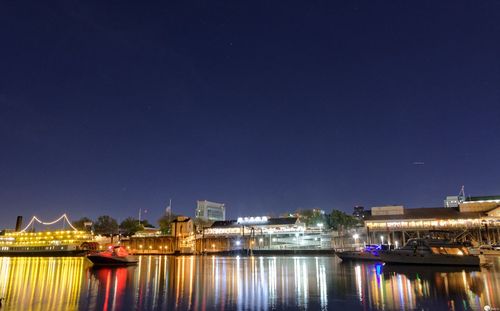 Boats moored in river at night