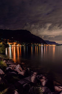 Scenic view of lake against sky at night