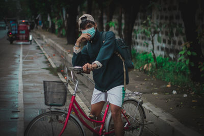 Rear view of man riding bicycle on street