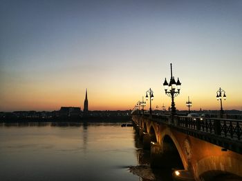 View of bridge over river in city at sunset