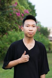 Portrait of young man gesturing while standing outdoors