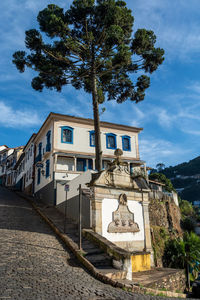 Low angle view of trees and buildings against sky