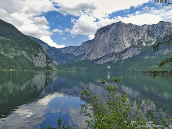 Scenic view of lake by mountains against sky