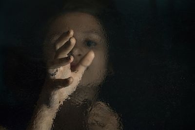 High angle view of girl emerging hand from lake