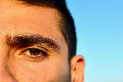 Close-up portrait of man against blue sky