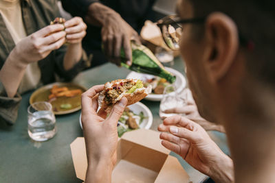 Man eating burger at restaurant