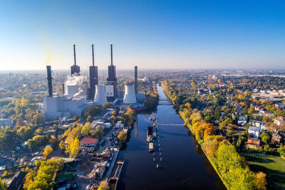 Aerial view of city against clear blue sky during sunny day