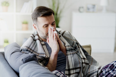 Man sitting on sofa at home