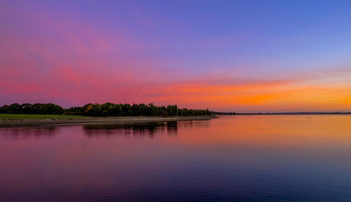 Scenic view of lake against sky at sunset