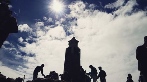 Low angle view of silhouette people against sky