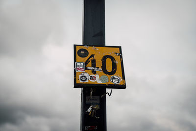 Low angle view of information sign against sky