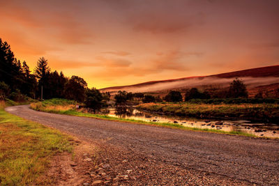 Dirt road passing through field