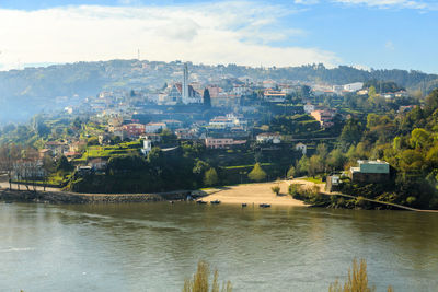 River amidst buildings in city against sky