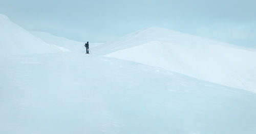 People on snowcapped mountain against sky