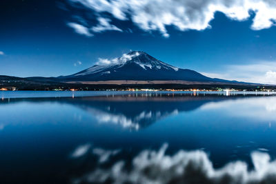 Scenic view of lake and mountains against blue sky