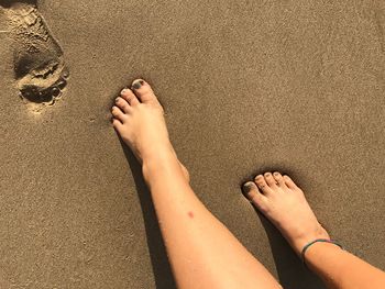 Low section of person lying on sand