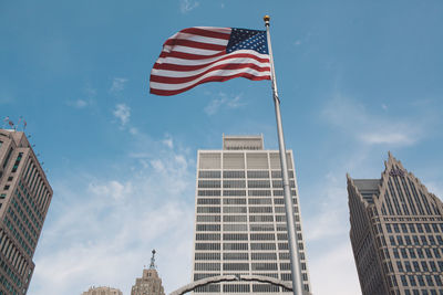 Low angle view of flag against buildings and sky