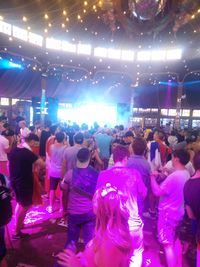 Crowd of people in illuminated street at night