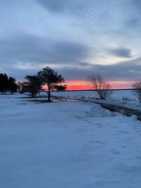 Scenic view of frozen lake against sky during sunset
