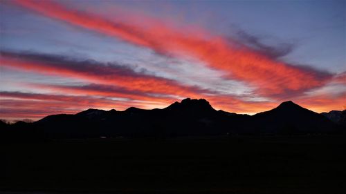 Scenic view of silhouette mountains against dramatic sky