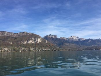 Scenic view of lake by mountains against sky