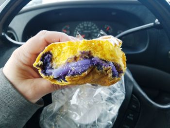 Close-up of hand holding ice cream cone in car