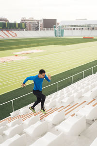 Side view of man skateboarding against building