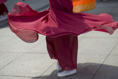 Low section of woman standing on footpath