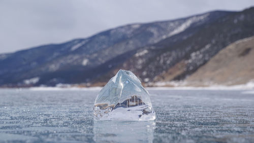 Close-up of frozen sea against mountain