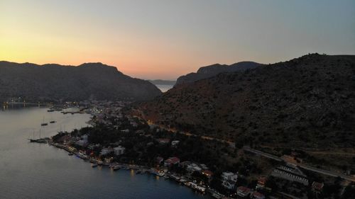 High angle view of buildings by sea against sky during sunset