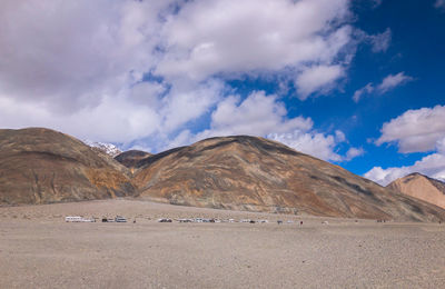 Scenic view of road by mountains against sky