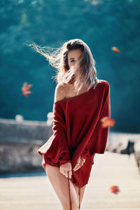 Portrait of woman with tousled hair standing outdoors