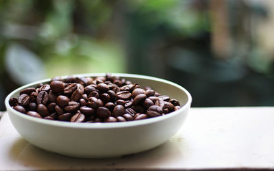 Close-up of coffee beans in bowl on table