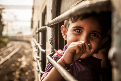 Portrait of boy looking through train window