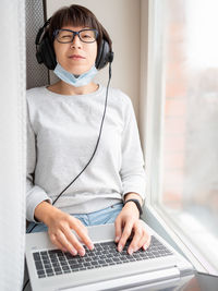 Full length of young woman using mobile phone