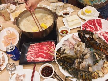 Close-up of hand holding ice cream in bowl on table