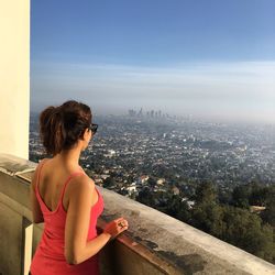 Woman looking at city against sky