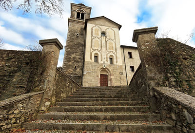 Low angle view of steps amidst buildings against sky