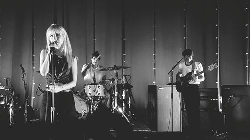 Panoramic shot of young woman playing piano at night