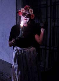 Portrait of woman wearing mask against wall