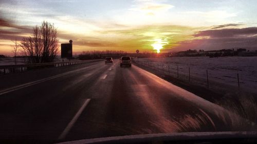 Cars on road at sunset