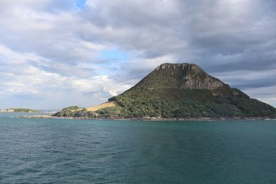 Scenic view of sea and volcano against sky