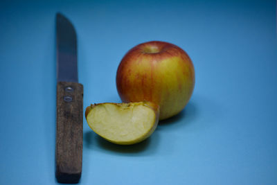 Close-up of apple on table against blue background