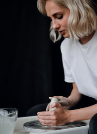 Side view of young woman making coffee