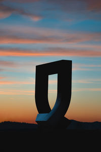 Silhouette of sculpture at sunset