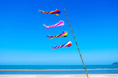 Colorful decorations at beach against clear blue sky