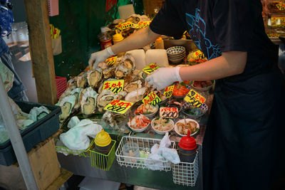 Midsection of man for sale at market stall