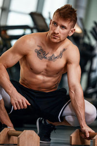 Shirtless muscular man exercising in gym